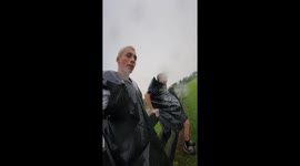 Friends slide down grassy slope with garbage bag in Augusta, Georgia