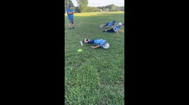 Boy fixes push-up form during football practice in Stanley, North Carolina