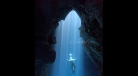 Cave View of a Freediver Swimming Through Bubble Rings