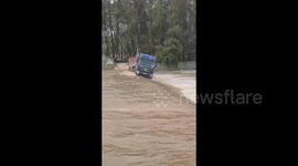 Terrifying moment truck plunges into overflowing river, driver makes miraculous escape