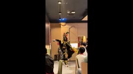 Tourists delighted by traditional Chinese mask dancer in restaurant