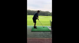 Golf club flies from player's hand as he practices at range