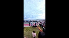 Onlookers flee as wave hits wall and seawater surges onto road