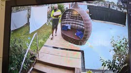 Delivery man protects parcel and sheets from rain in Kingston, Queensland
