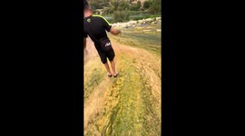 Man slips and slides on mossy riverbank in Tivenys, Spain