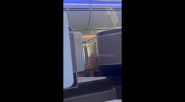 Dude Using Bare Feet to Use Airplane Screen