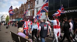 British patriots walking down Sutton Town Centre High Street waving flags and chanting.
