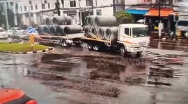 Concrete pipe falls from truck onto road
