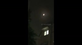 Nighttime lunar eclipse over cityscape in Delhi, India