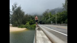 Big river jump sends splash chasing a passing car in Hawaii, USA