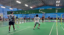 Badminton player accidentally strikes teammate in the back with shuttlecock