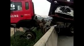 Lorry hangs off the edge of a bridge, facing a 100 metre drop