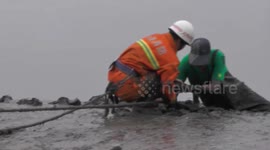 Firefighters rescue an elderly man trapped in wet sand