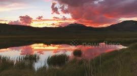 US: Golden And Purple Sky Glows Over Swan Lake Flat
