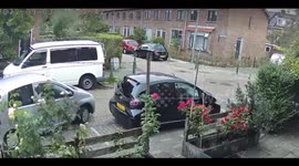 Gray car scrapes parked vehicle on narrow street in Rotterdam, Netherlands