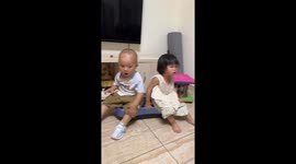 Two children enjoy a shaking vibration platform in Guizhou, China