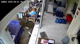 Worker slips carrying water container in Binjai, Indonesia