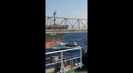 Tugboat helps oil tanker with mooring in choppy sea