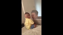 Father plays peek-a-boo with toddler behind mosquito net