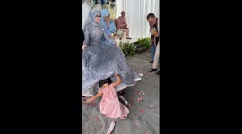 Toddlers hide in bride's skirt as she poses for wedding photos