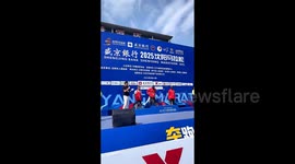Exhausted collapses on podium after winning marathon in China