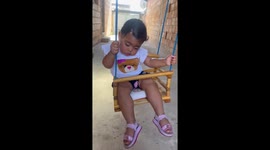 Toddler dozing on swing in Betim, Brazil
