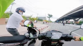 Kind motorcycle rider helps fellow road user push his broken-down vehicle