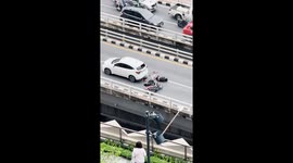 Motorcycle rider knocked over on busy road in Bangkok