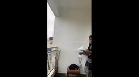 Woman Falls From Stool While Hanging Balcony Curtains