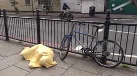 Yellow mummy lie-down outside Earls Court station on Warwick Road - showing signs of life