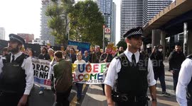 Stand Up To Racism protesters are escorted by police to Surrey Quays from a migrant hotel in Canary Wharf