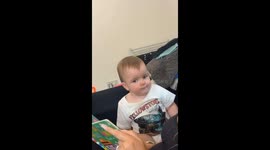 Baby Laughs at His Mom Reading a Book