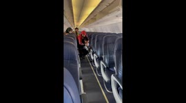 Kind flight attendant piggy-backs disabled passenger through the aisle and down steps