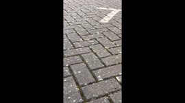 Unexpected road bump while man retrieves football in Bushey, UK