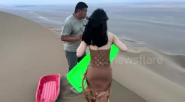 Woman enjoys thrilling sand dune slide in China