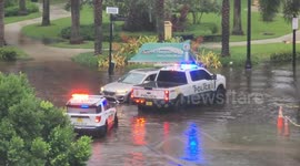 US: Police assists a stalled car on a flooded road in Sunny Isles Beach, FL