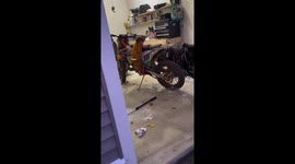 Little boy starts dirt bike in garage in Milford, Massachusetts, USA