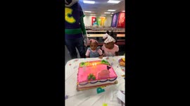 Big sister helps little one blow out birthday candle in Greenville, South Carolina, USA
