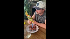 Guy Reading a Birthday Card as the Candle Lights It on Fire