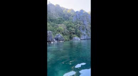 Tourists admire breathtaking lagoon with clear waters and mountain views in the Philippines