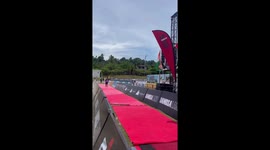 Crowd cheers plus size runner over the finish line at ironman race