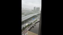 Determined rider pushes his motorcycle along bridge during typhoon
