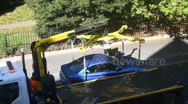 A car being lifted on to a Lorry by Hoist and