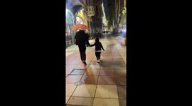 Siblings slip and fall on wet pavement in Tbilisi, Georgia