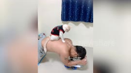 Pet owner exercises with pet cat supervising him