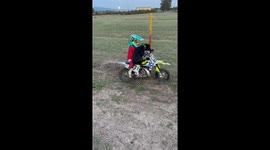 Boy and Staffordshire Bull Terrier ride mini motocross bike in Sardegna, Italy