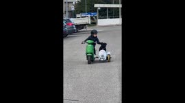 Boy rides mini scooter with Staffordshire Bull Terrier in Sardegna, Italy