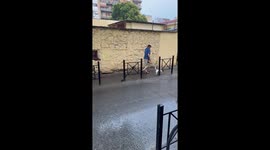 Loyal dog owner covers head with newspaper while walking his pet through rain