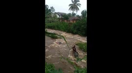 Boy stranded on rock during raging floods is rescued by locals