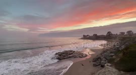 Sunset over calm ocean with rocky shore in Santa Cruz, USA